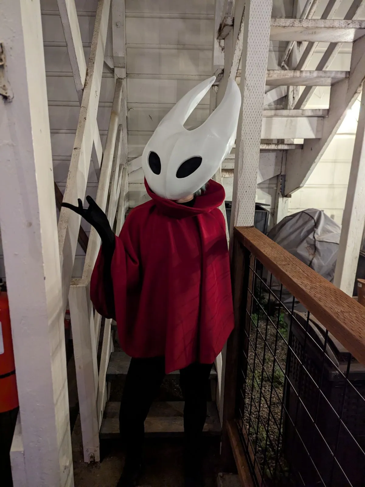 The same Hornet costume from a three quarter angle on the staircase, one arm raised