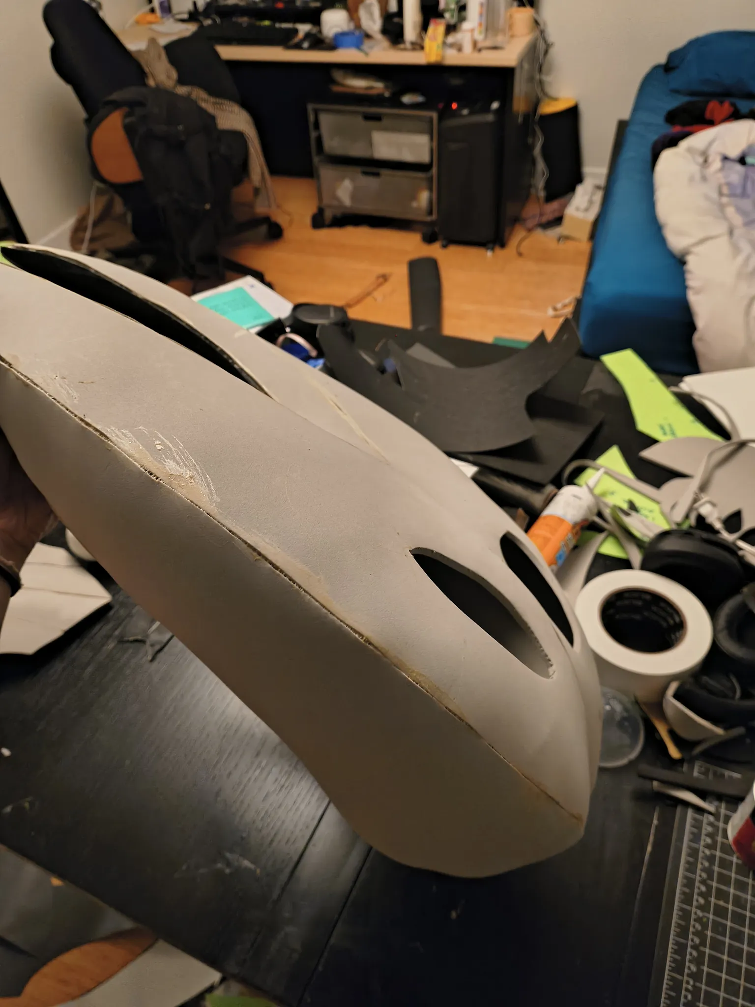 The glued gray foam mask from the front on a cluttered desk
