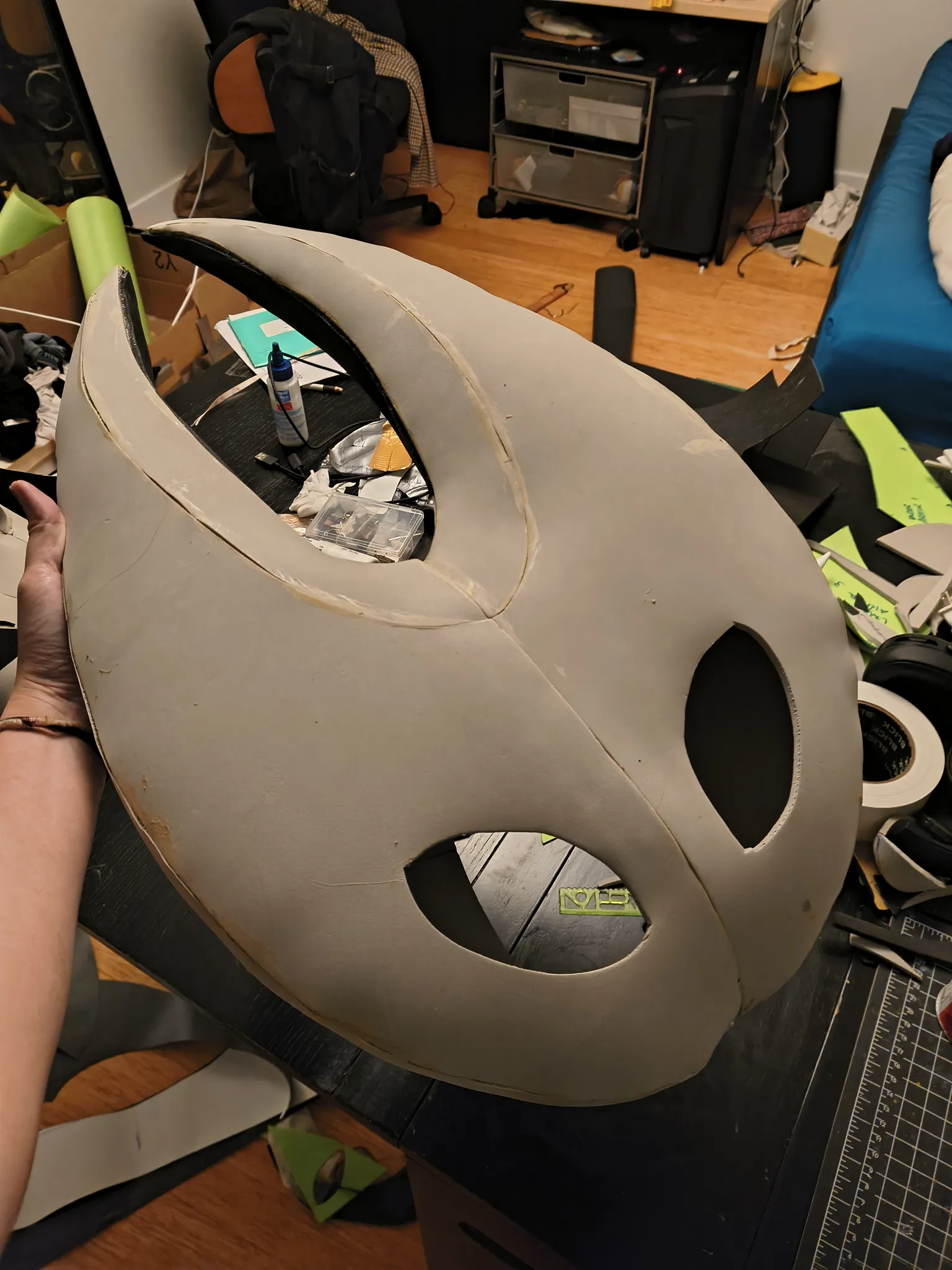 The glued gray foam mask from the side, showing the two horns and the eye holes