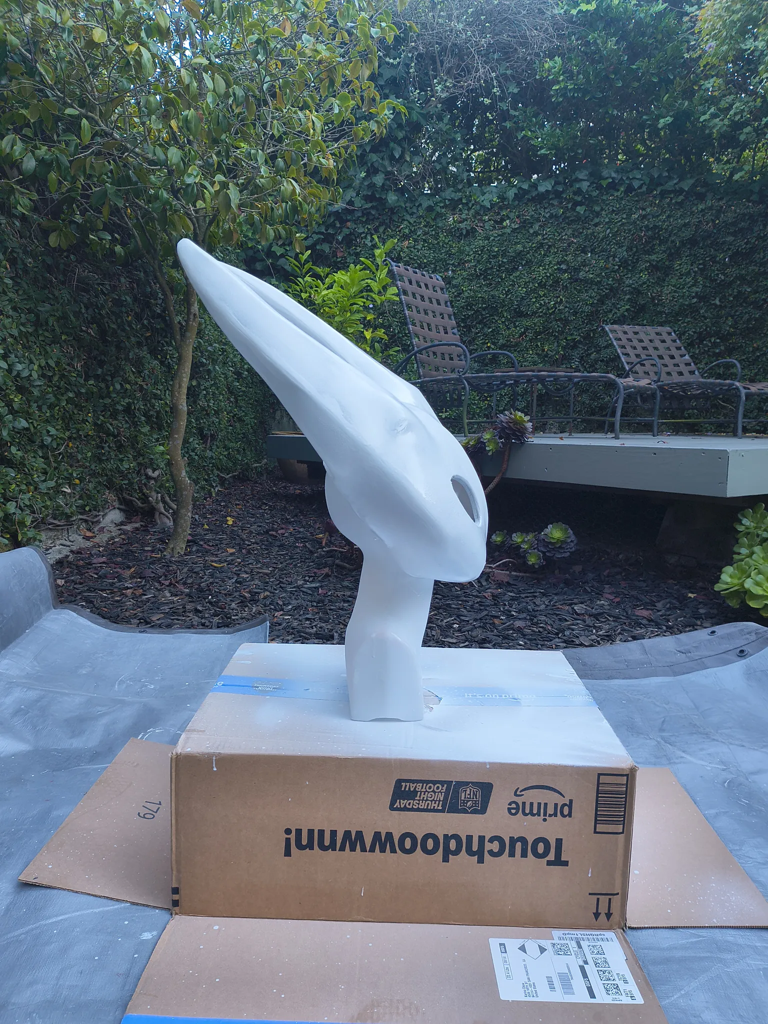 The white mask on the cardboard box from the side, with the horns in profile