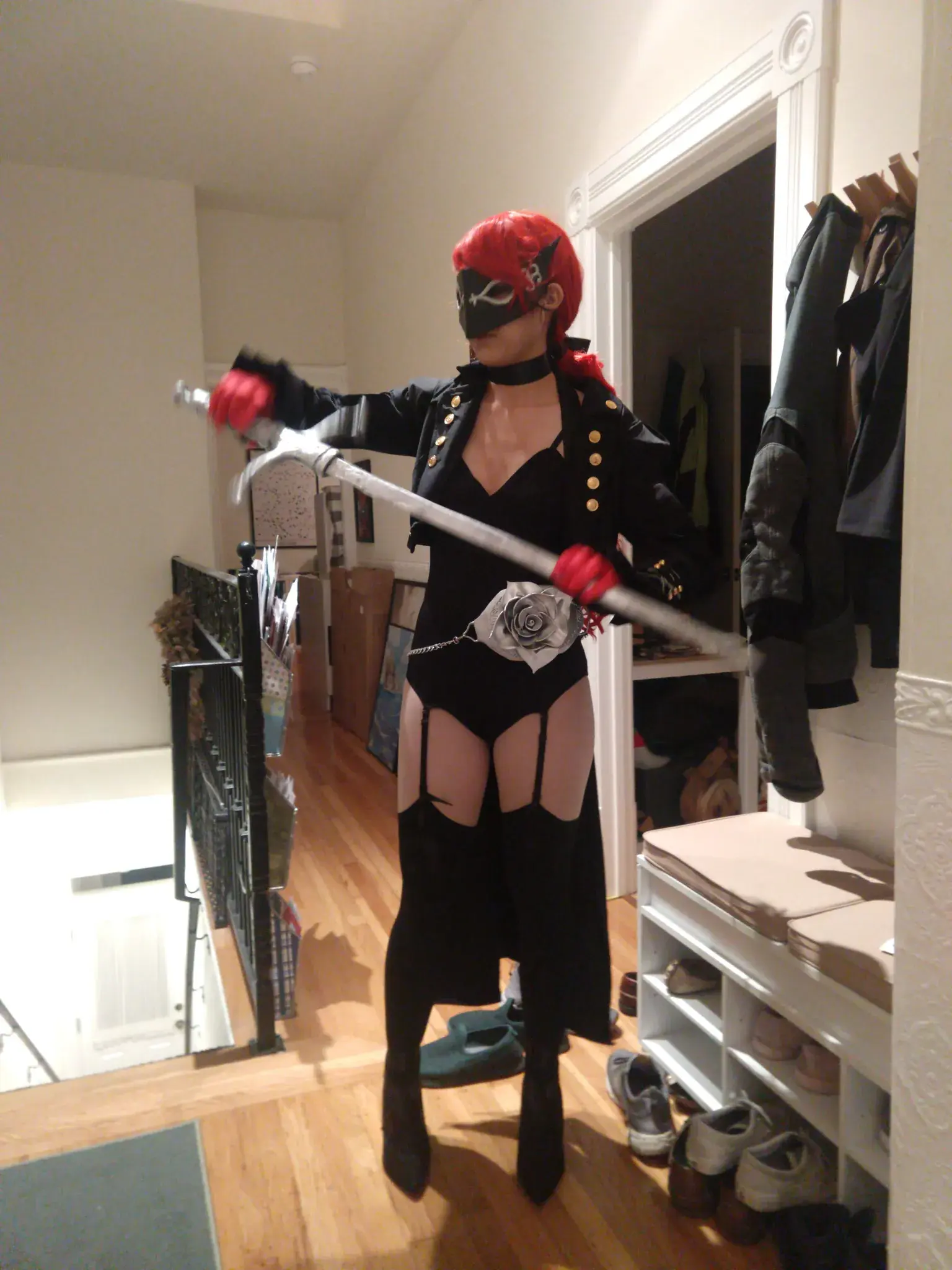 Photograph of a girl in a red wig and black leotard pulling out a sword