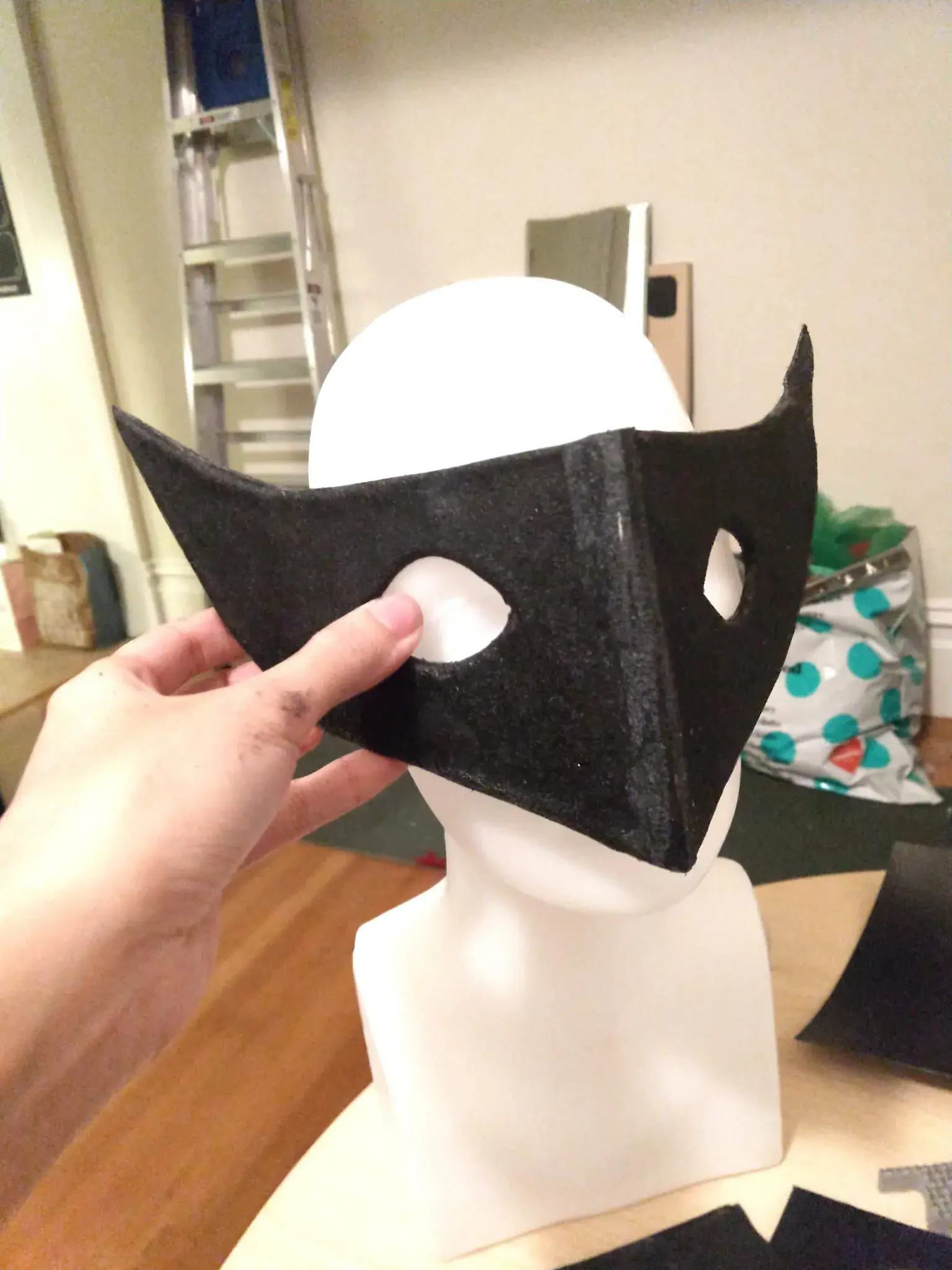 Photograph of a black mask sitting on a head mannequin