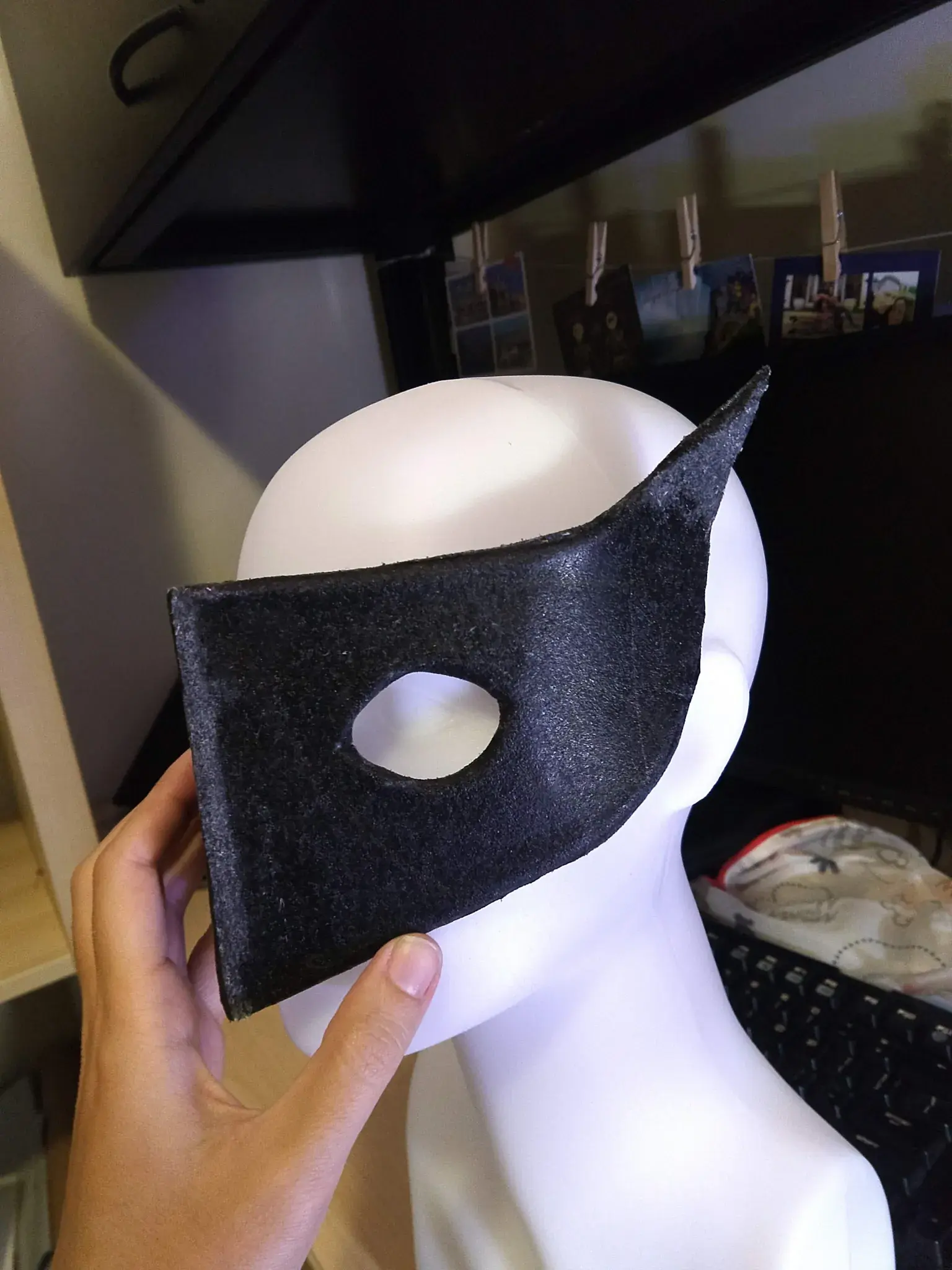 Photograph of a black mask sitting on a head mannequin