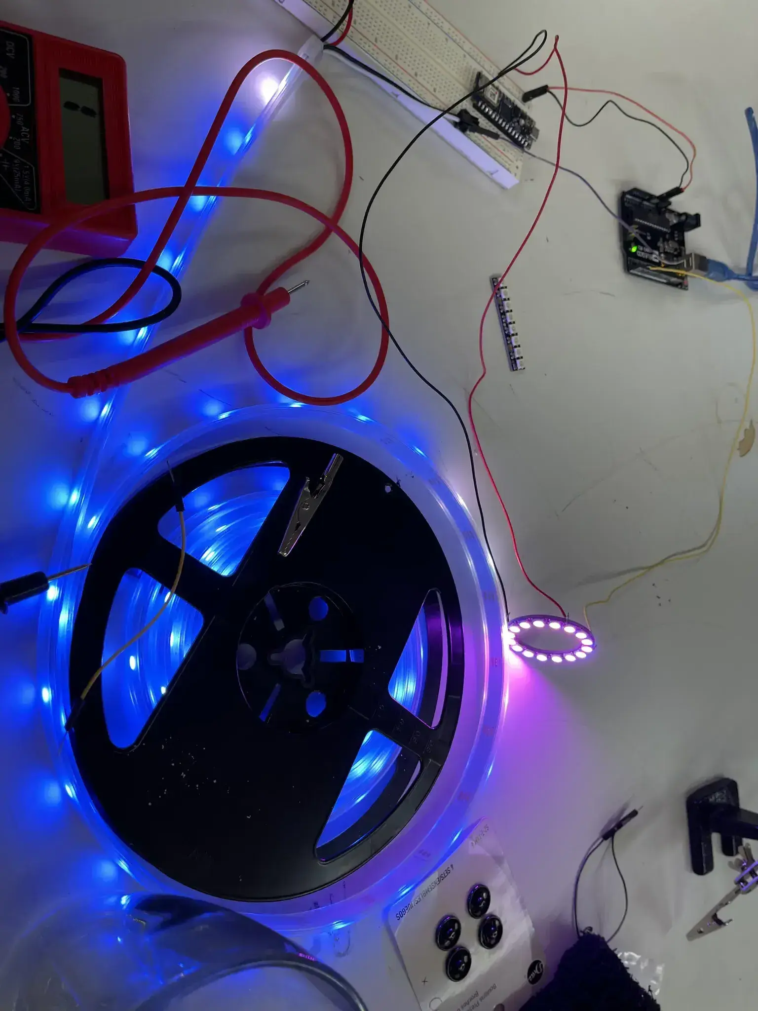 Photograph of a coiled up roll of addressable LEDs on magenta