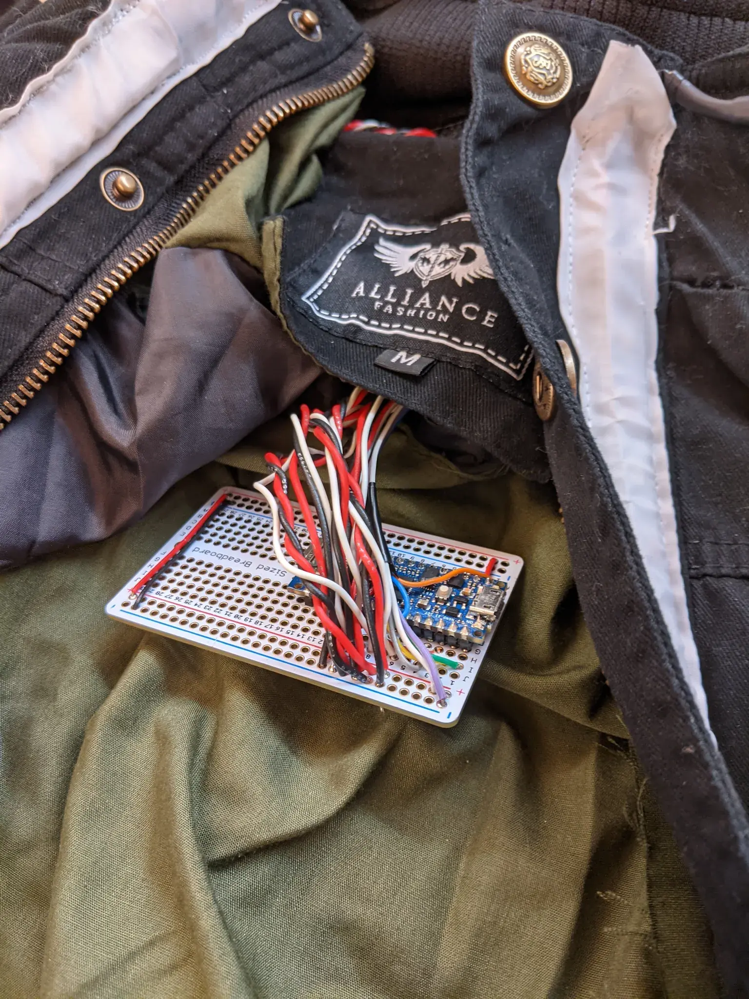 Photograph of a protoboard with tons of red and black wires coming from it