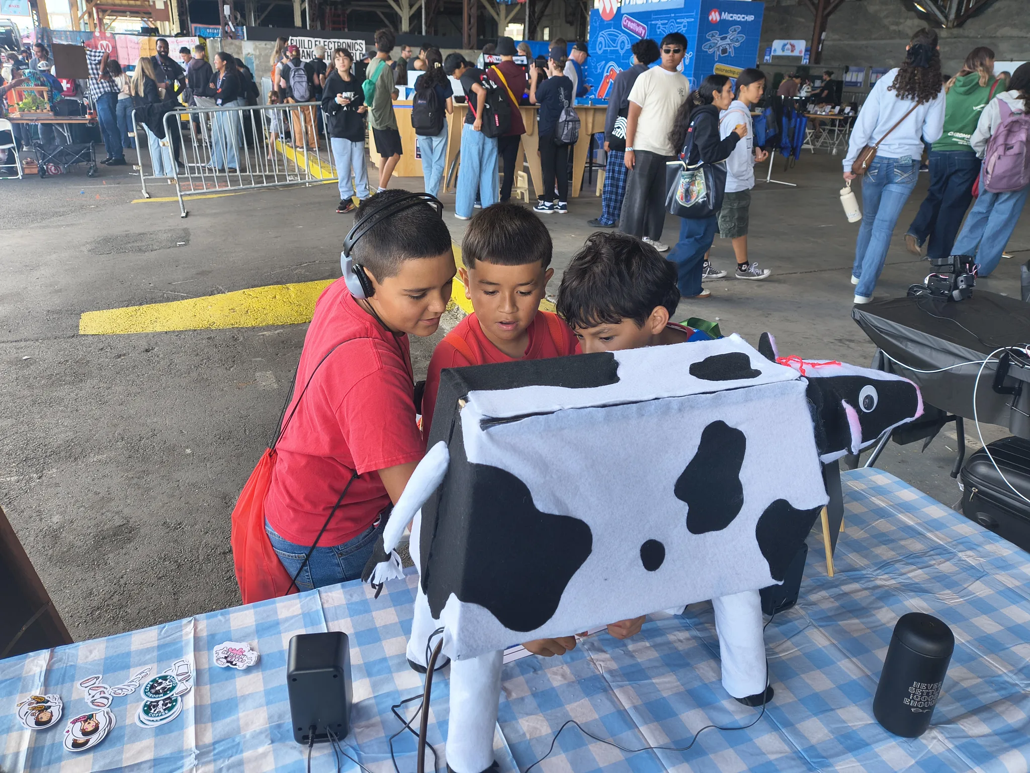 Photograph of two boys in red shirts squeezing the udder together